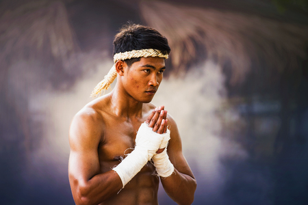 The fighter tying tape around his hand preparing to fight,Thai boxing at the river,Boxing fighters trainning outdoor,Muay Thaiの写真素材