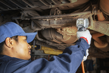 Hands of car mechanic with wrench in garage.Auto mechanic working in auto repair service.Repair service.Car repair and maintenance.の写真素材