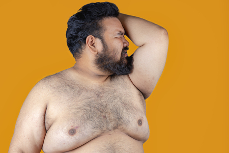 Fat men on a yellow background. Fatman are stressed about losing weight. Fat man with a big belly. Diet.の写真素材