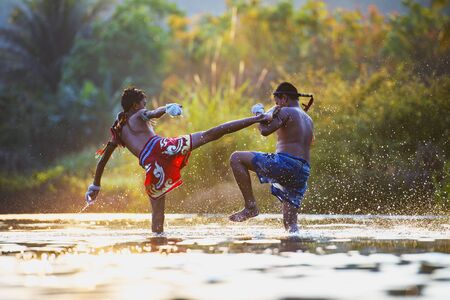 The fighter tying tape around his hand preparing to fight,Thai boxing at the river,Boxing fighters trainning outdoor,Muay Thaiの写真素材