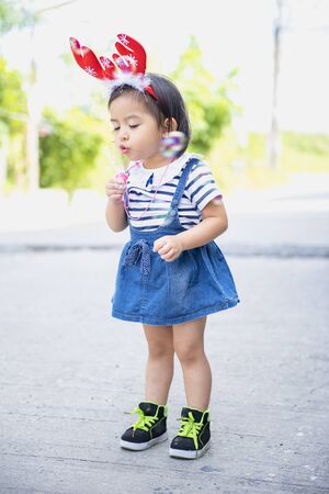 Cute little Asian girl is enjoying the player on the playground. Little girl playing bubble.の写真素材