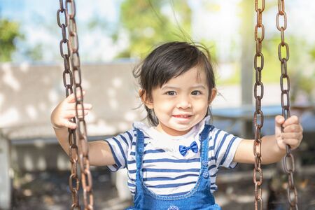 Cute little Asian girl is enjoying the player on the playground. Little girl playing at the playground.の写真素材