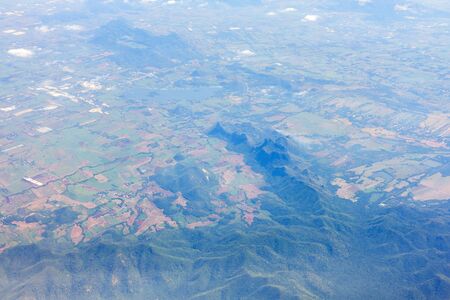 Aerial view of mountains, rivers, clouds, Agricultural Landscape areas the green and yellow rice field, Aerial view of grew in different pattern, And housing.Remote viewing.の写真素材