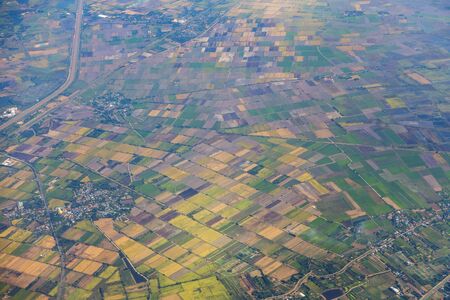 Aerial view of mountains, rivers, clouds, Agricultural Landscape areas the green and yellow rice field, Aerial view of grew in different pattern, And housing.Remote viewing.の写真素材