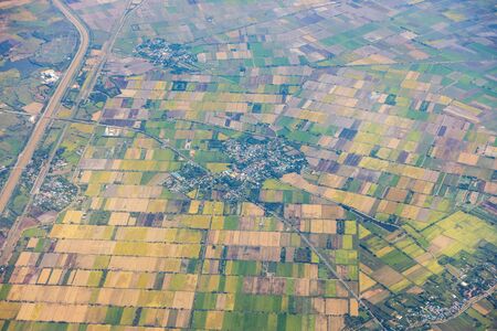 Aerial view of mountains, rivers, clouds, Agricultural Landscape areas the green and yellow rice field, Aerial view of grew in different pattern, And housing.Remote viewing.の写真素材