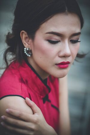 Close-up of young woman in Chinese dress with problems crying.の写真素材