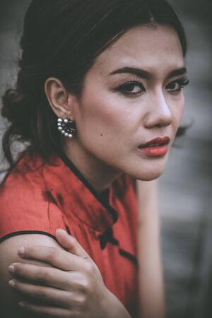 Close-up of young woman in Chinese dress with problems crying.の写真素材