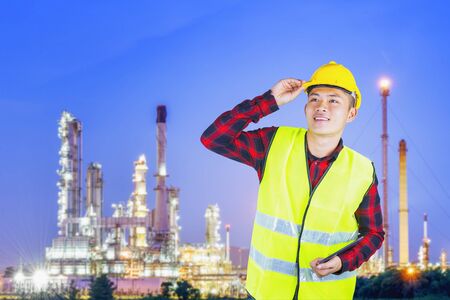 Young engineer with safety helmet with oil refinery industry plant background.の写真素材