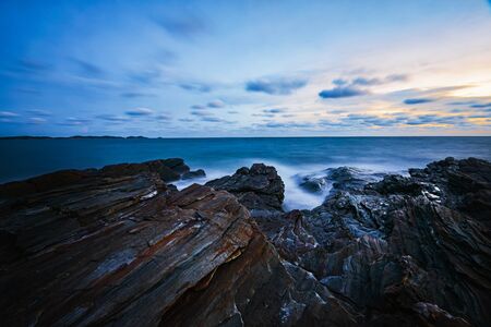  Sea waves hitting rocks on the beach with foam. Powerful Waves on a rocky beach. Stormy windy weather. Storm wave hits and rolls over limestone rock.の写真素材