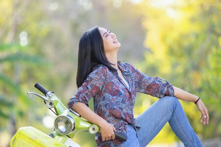 beautiful girl with a classic motorcycle. Biker girl sitting on vintage custom motorcycle.の写真素材