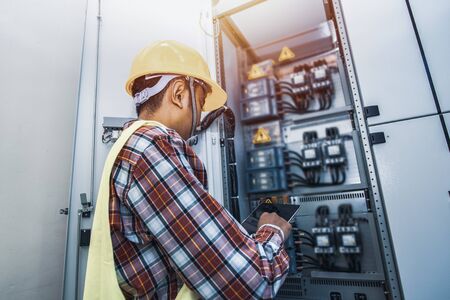 Control cabinet ,Control Room Engineer. Power Plant Control Panel. Engineer standing in front of the control panel in the control room.の写真素材