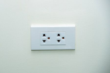 Power plug, White wall socket on wall, electric socket with one button, Power outlet on white wall.の写真素材