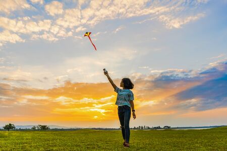 Happy girl running with a kite at sunset outdoors, Little girl running with kite in the field on summer day with sunset.
の写真素材