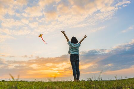 Happy girl running with a kite at sunset outdoors, Little girl running with kite in the field on summer day with sunset.
の写真素材
