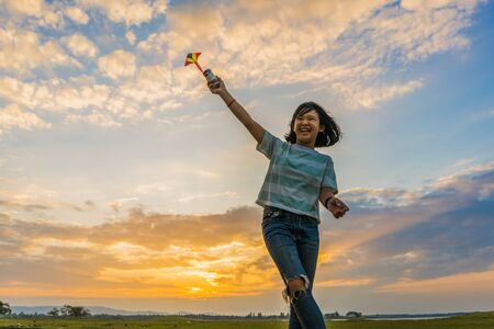 Happy girl running with a kite at sunset outdoors, Little girl running with kite in the field on summer day with sunset.
の写真素材