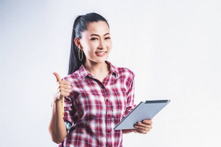 Beautiful young working women grinning professional in office confident expression. A confident young woman is checking the job. Have the opportunity to work everywhere.の写真素材