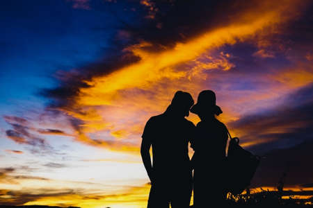 Silhouettes couples with sunset , Romantic couple in love together with sunset, Silhouettes of young man and woman in love on holidays or honeymoon.の写真素材
