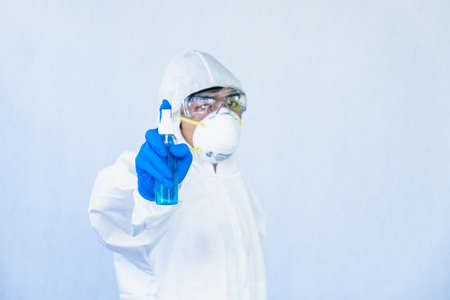 Doctors wear a face shield / PPE for protection against coronavirus disease. The doctor recommends using alcohol to clean to kill the coronavirus.の写真素材
