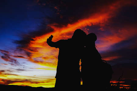 Silhouettes couples with sunset , Romantic couple in love together with sunset, Silhouettes of young man and woman in love on holidays or honeymoon.の写真素材