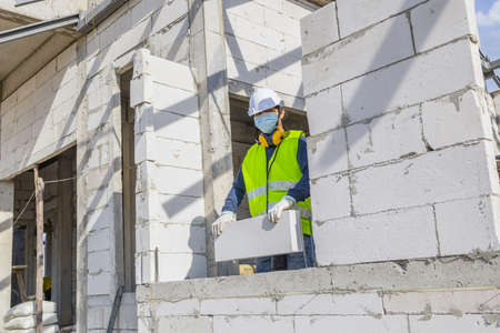 Unpainted lightweight brick wall, Lightweight bricks that are placed together for building walls with in the building, House construction  building site with lightweight bricks.の写真素材