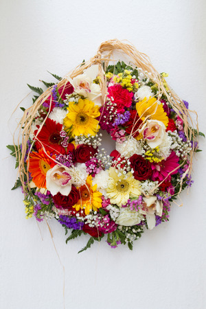 Easter Flower Wreath hanging on a whitewashed wallの写真素材