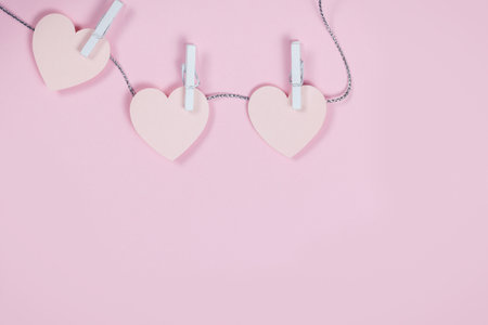 Pink hearts from paper scattered on pink background love wedding concept. Valentines day background. Flat lay top view. Copy spaceの写真素材