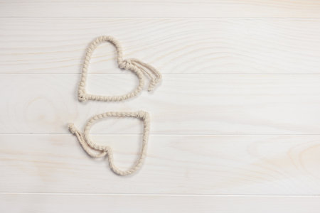 Flatlay composition with beautiful cute rope hearts on a white wooden background. Valentines Day....
