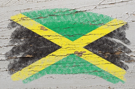 Chalky jamaican flag painted with color chalk on grunge wooden textureの写真素材
