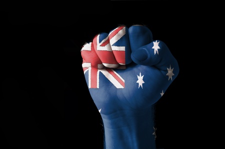 Low key picture of a fist painted in colors of australia flagの写真素材
