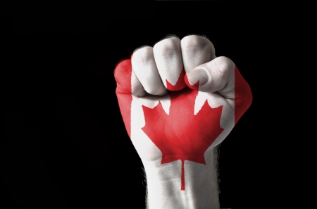 Low key picture of a fist painted in colors of canada flagの写真素材