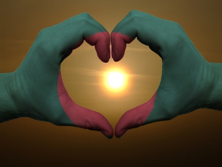 Gesture made by bangladesh flag colored hands showing symbol of heart and love during sunriseの写真素材