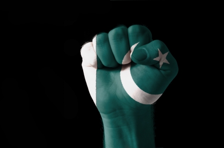 Low key picture of a fist painted in colors of pakistan flagの写真素材
