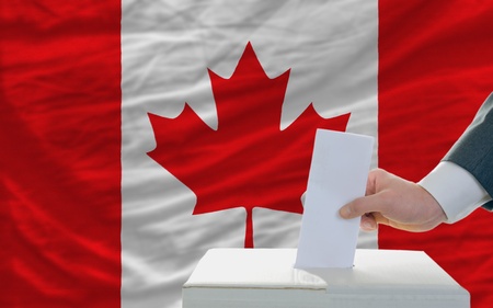 man putting ballot in a box during elections in canadalの写真素材
