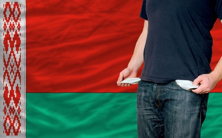 poor man showing empty pockets in front of belarus flagの写真素材