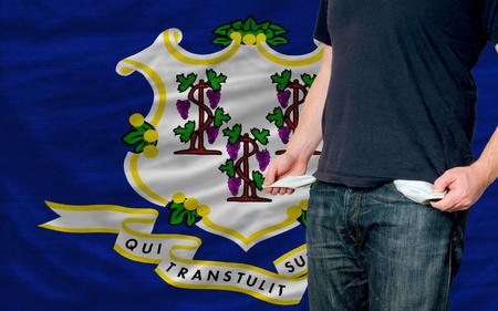 poor man showing empty pockets in front of conneticut flagの写真素材