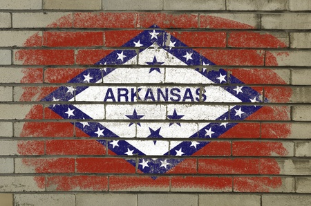 Chalky and grunge american state of arkansas flag painted with color chalk on brick wallの写真素材