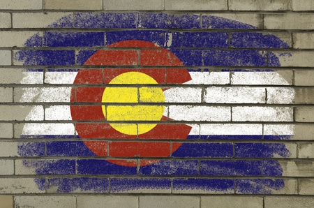 Chalky and grunge american state of colorado flag painted with color chalk on brick wallの写真素材