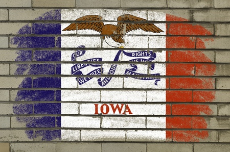 Chalky and grunge american state of iowa flag painted with color chalk on brick wallの写真素材