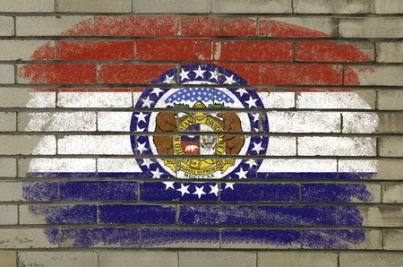 Chalky and grunge american state of missouri flag painted with color chalk on brick wallの写真素材