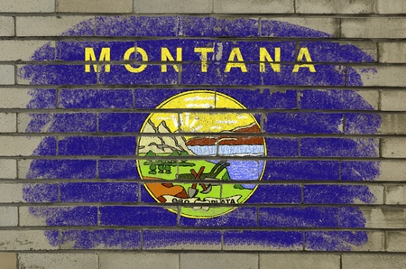 Chalky and grunge american state of montana flag painted with color chalk on brick wallの写真素材