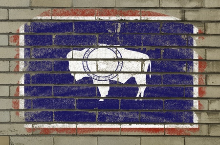 Chalky american state of wyoming flag painted with color chalk on brick wallの写真素材