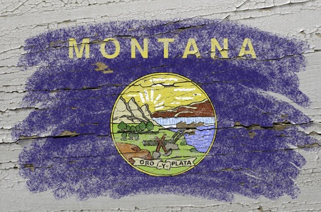 Chalky american state of montana flag precisely painted with color chalk on grunge wooden textureの写真素材