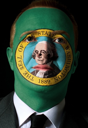 High key portrait of a serious businessman or politician whose face is painted in american state of washington flagの写真素材