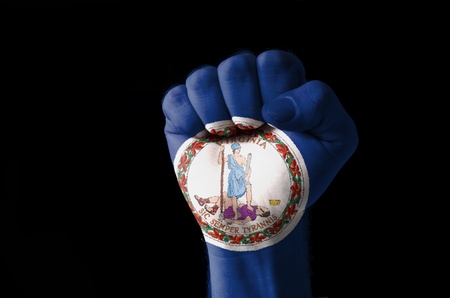 Low key picture of a fist painted in colors of american state flag of virginiaの写真素材