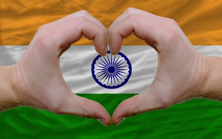 Gesture made by hands showing symbol of heart and love over flag of indiaの写真素材