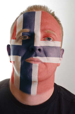 High key portrait of a serious man whose face is painted in national colors of norwayの写真素材