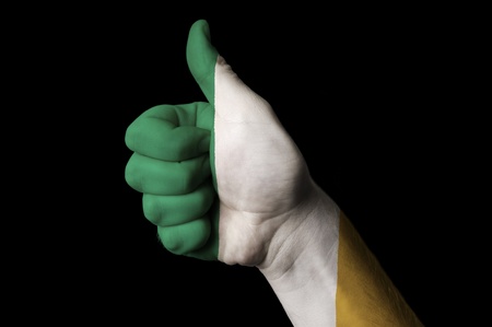 Hand with thumb up gesture in colored ireland national flag as symbol of excellence, achievement, good, - useful for tourism and touristic advertising and also current positive political, cultural, social management of state or countryの写真素材
