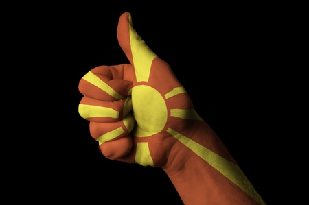 Hand with thumb up gesture in colored macedonia national flag as symbol of excellence, achievement, good, - useful for tourism and touristic advertising and also current positive political, cultural, social management of state or countryの写真素材