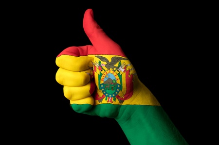 Hand with thumb up gesture in colored bolivia national flag as symbol of excellence, achievement, good, - for tourism and touristic advertising, positive political, cultural, social management of countryの写真素材