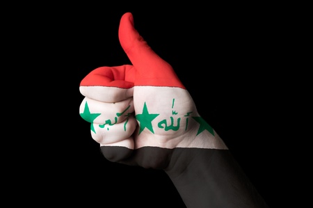 Hand with thumb up gesture in colored iraq national flag as symbol of excellence, achievement, good, - for tourism and touristic advertising, positive political, cultural, social management of countryの写真素材